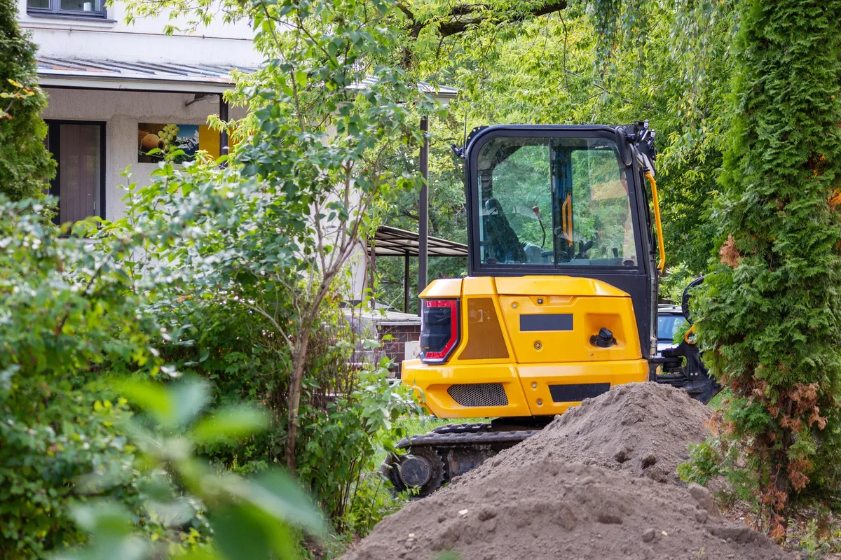 A bulldozer is actively working on a construction site for a new home, illustrating heavy machinery use.