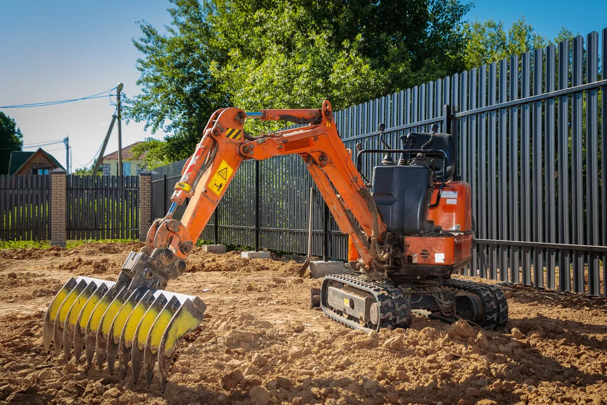 A mini excavator working on an agricultural plot, illustrating its versatility for various projects.