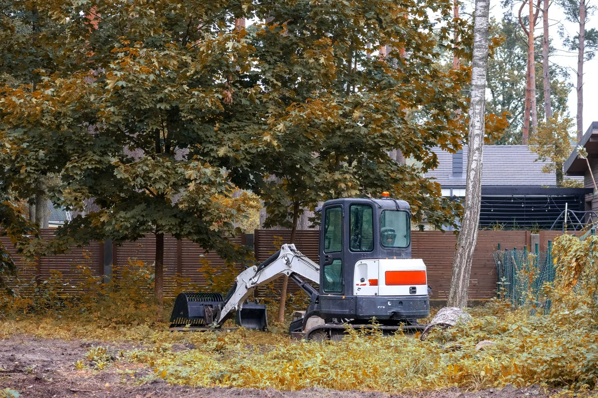 A small tracked loader working on a construction site, illustrating the use of mini excavators.